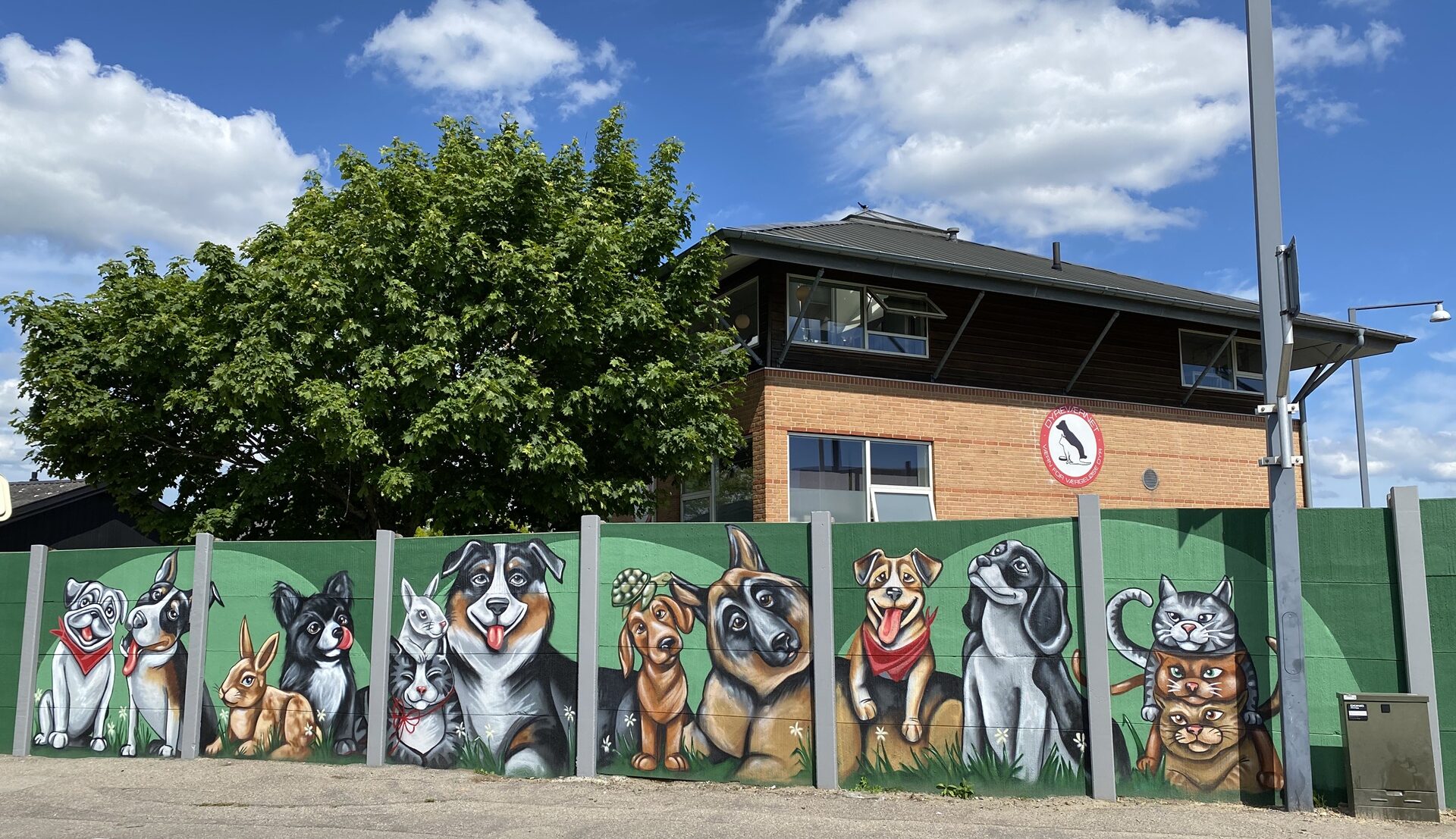 Billede af Dyreværnets facade i Rødovre. På billedet ses hovedbygning samt mur med murmaleri med håndmalede dyr.